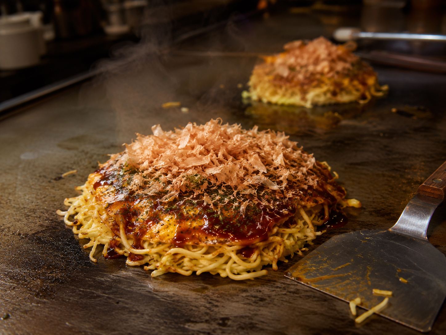 広島お好み焼き。鉄板で焼かれるそば入りのお好み焼き。