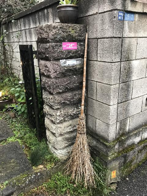 石壁にもたれた箒