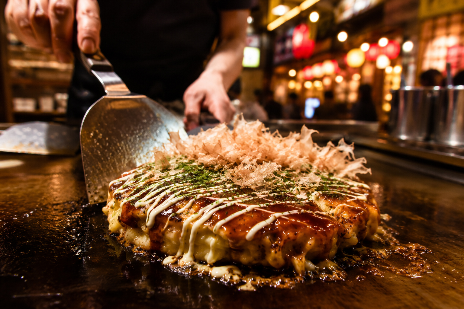 道頓堀の鉄板で焼かれるお好み焼き。